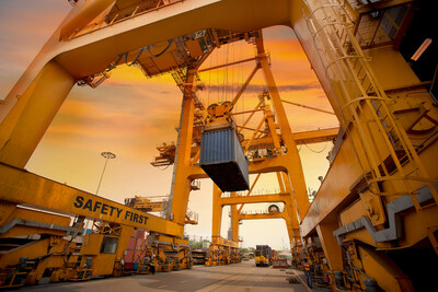 Courtesy of Shutterstock. Crane lifts a shipping container during port operations.
